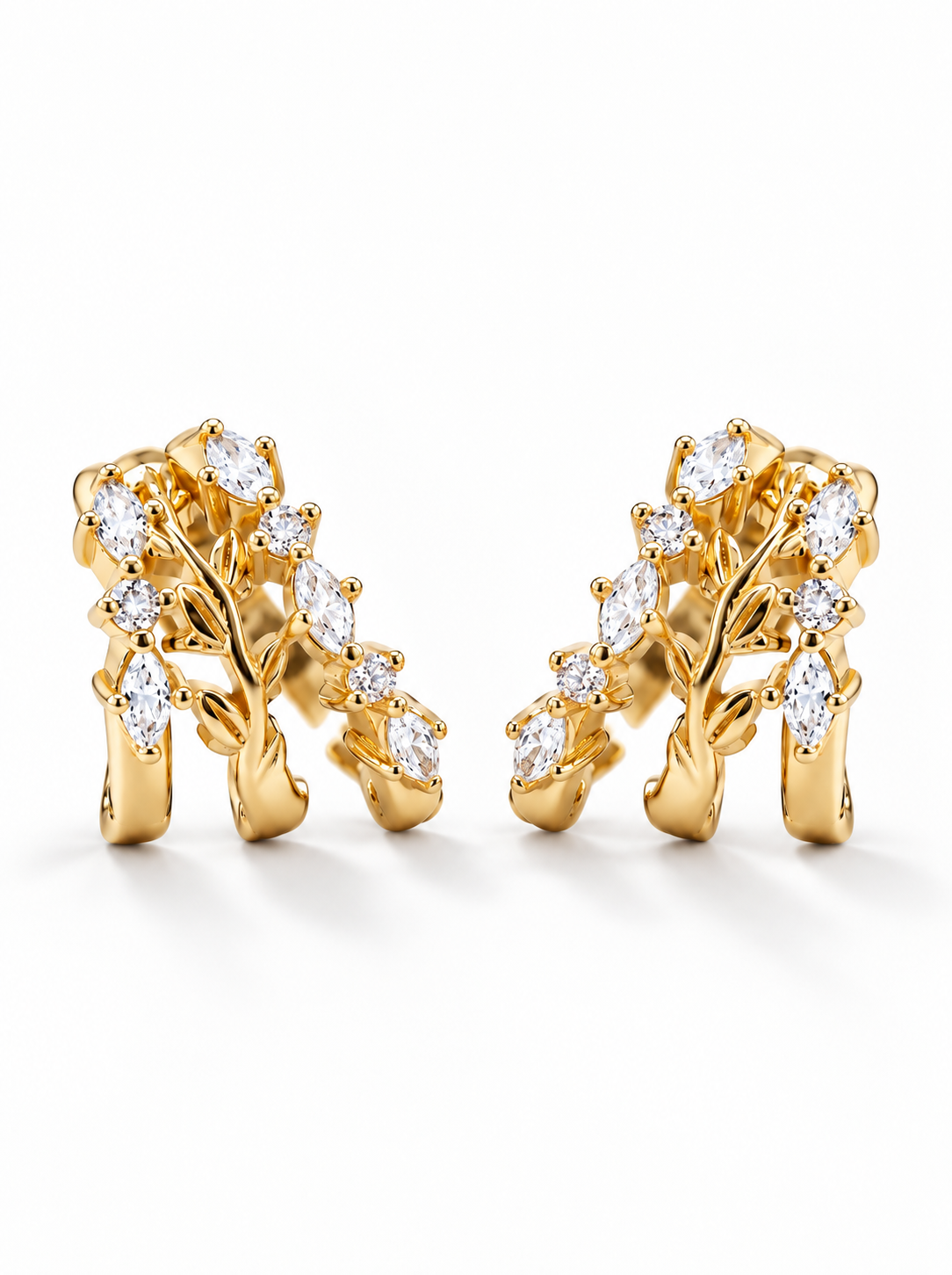 A pair of gold tree branch earrings adorned with marquise-cut clear gemstones, displayed on a clean white background.