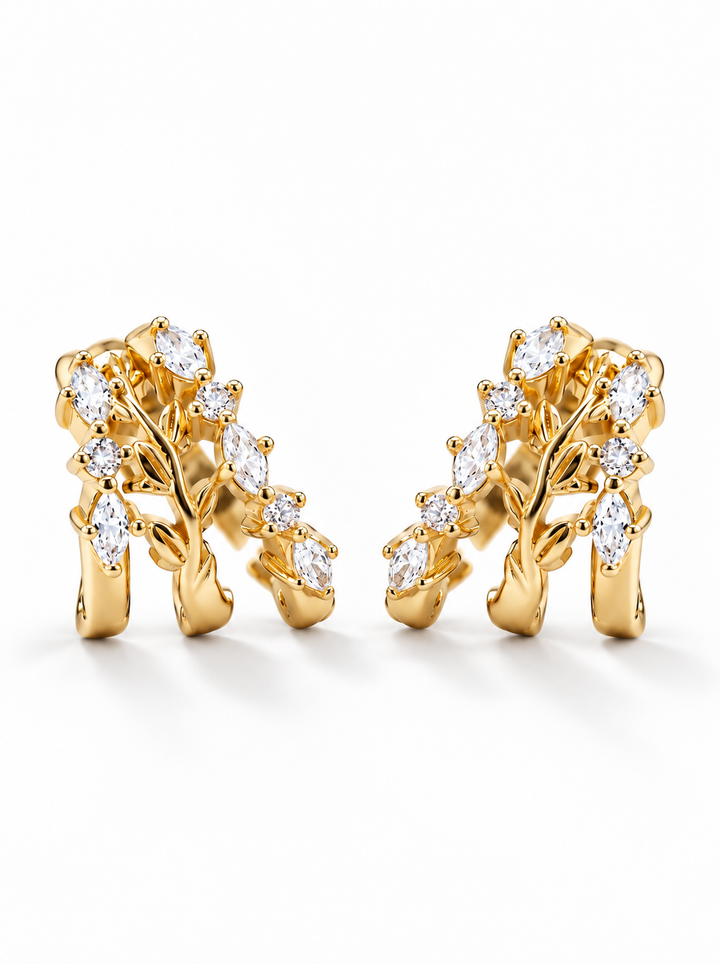 A pair of gold tree branch earrings adorned with marquise-cut clear gemstones, displayed on a clean white background.