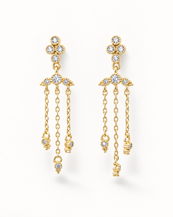 A pair of gold dangle earrings with clear gemstones, displayed against a clean white background.